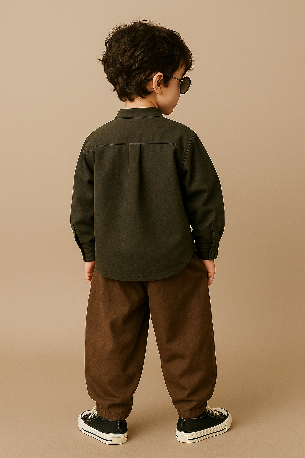 Young boy wearing modern kids clothing style with dark green shirt and brown pants from The Thugster